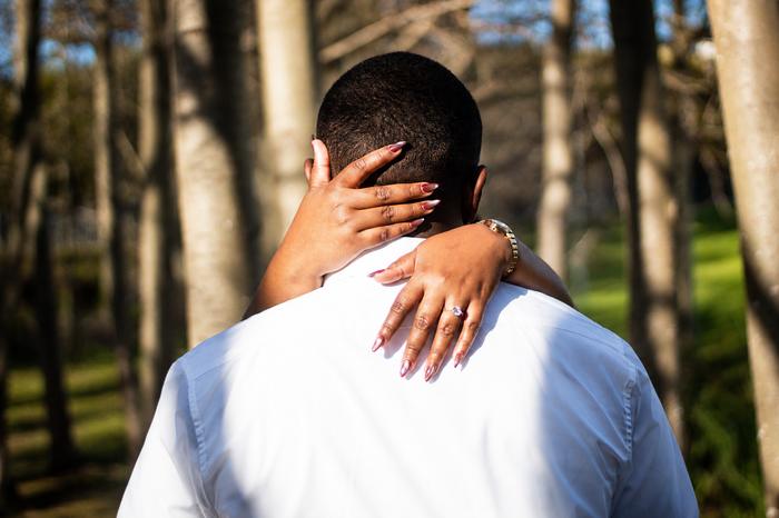 An embrace from behind among the trees