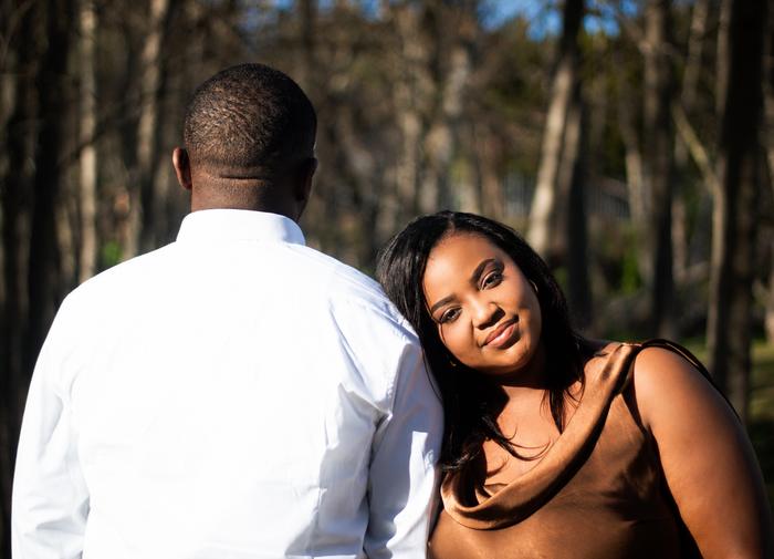 The bride-to-be smiling, leaning on her partner